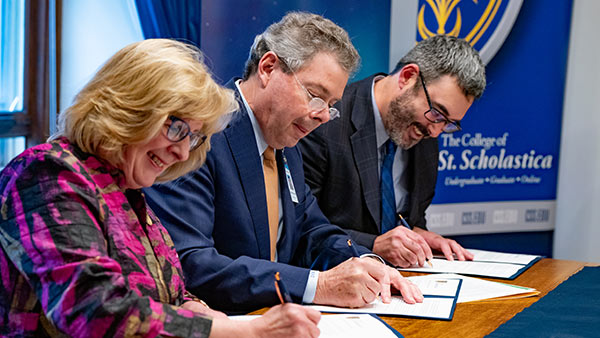 Photo of St. Scholastica President Barbara McDonald, Dr. David Herman, and Dr. Dr. Ryan Sandefer signing the patnership agreement