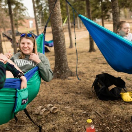 Students hanging out in Hammocks on the Duluth campus of St. Scholastica.