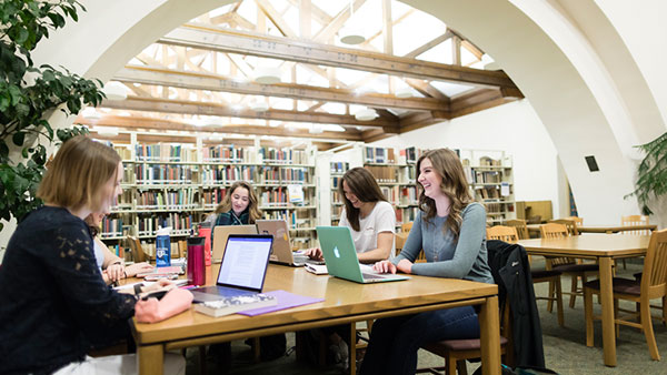 Group of St. Scholastica students studying in the library.